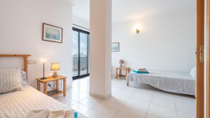 Une chambre d’hôtel avec deux lits, une fenêtre et une porte.