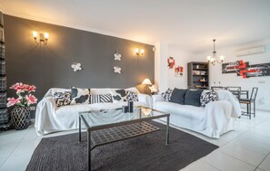 A modern living room with a sofa set, a coffee table, and a bookshelf. - Gorgeous apartment in Port de Pollenca with WiFi (Port de Pollenca)