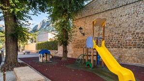 A playground with a yellow slide, climbing structures, and a bench. - 3 bedroom gorgeous apartment in Soller (Soller)