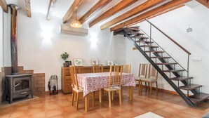 A dining area with a table set for four, a wooden staircase, and a fireplace. - 3 bedroom gorgeous apartment in Soller (Soller)