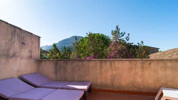 A rooftop terrace with two lounge chairs and a table, overlooking a mountainous landscape and flowering trees. - 3 bedroom gorgeous apartment in Soller (Soller)