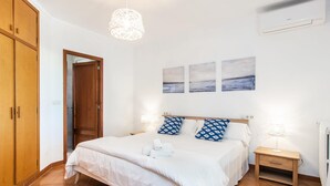 A bedroom with a bed, two nightstands, a wooden wardrobe, and a hanging light fixture. - Amazing home in Porto Cristo (Porto Cristo)