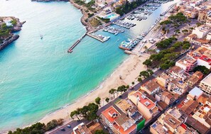 An aerial view of a coastal town with a marina, beach, and dense urban buildings. - Amazing home in Porto Cristo (Porto Cristo)