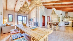 A spacious living area with a wooden dining table, benches, and hanging light fixtures. - Luxurious home in Campos with private swimming pool, can be inside or outside (Campos)