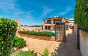 A two-story stone house with a swimming pool, a gated entrance, and a stone wall. - Cozy home in Manacor with private swimming pool, can be inside or outside (Manacor)