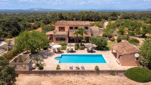 Een villa in mediterrane stijl met een zwembad, buitenzitplaatsen en uitzicht op het omliggende landschap.