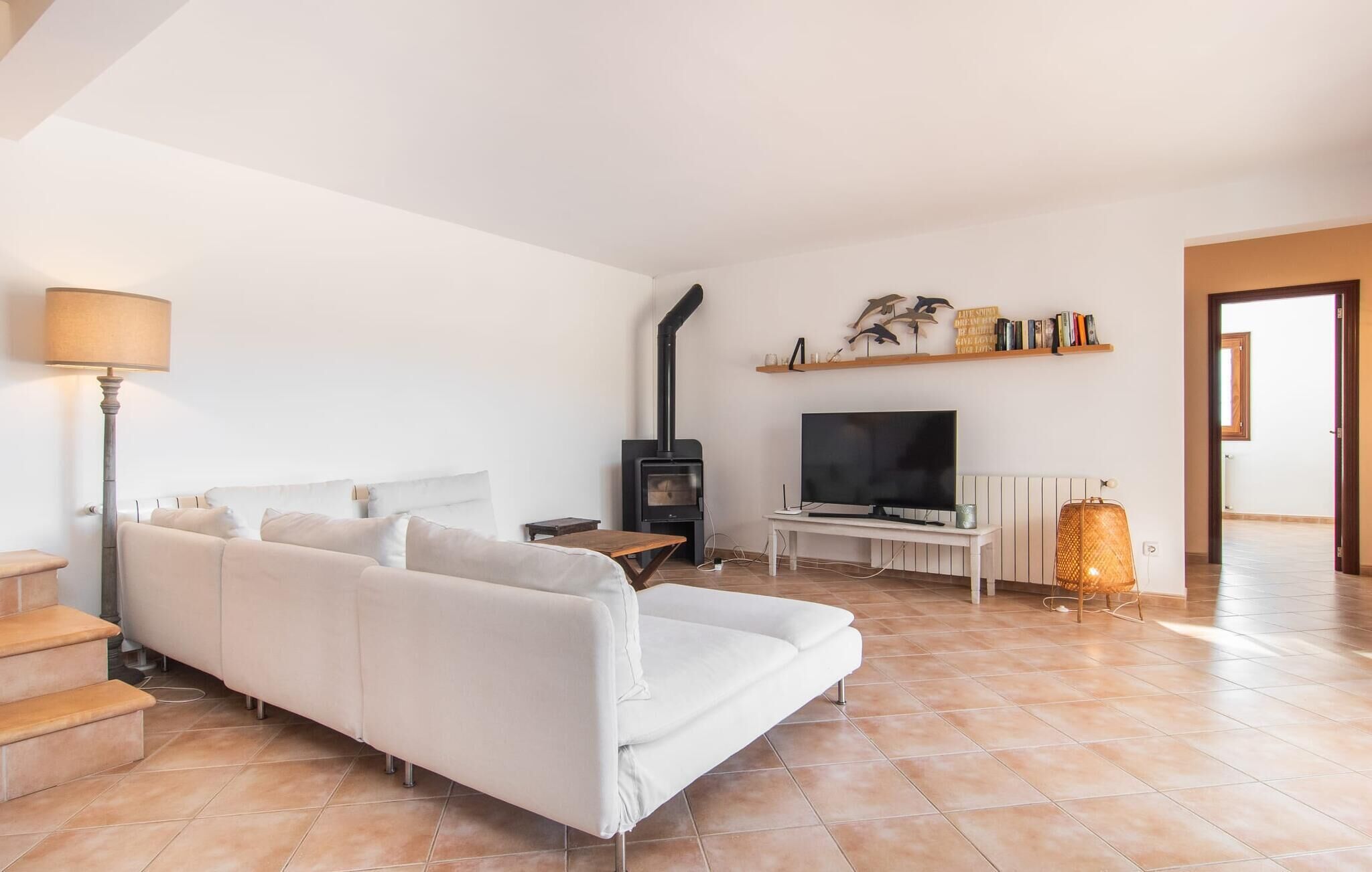 Un salon avec un canapé, un téléviseur, une cheminée et une lampe.