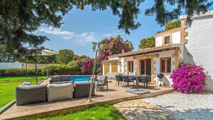 A poolside area with outdoor furniture, a barbecue, and a white building with a tiled roof. - Lovely home in Alcudia with private swimming pool, can be inside or outside (Alcudia)