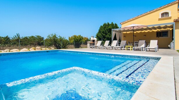 A clear blue swimming pool with lounge chairs and a covered seating area. - Beautiful home in Alcudia with private swimming pool, can be inside or outside (Alcudia)