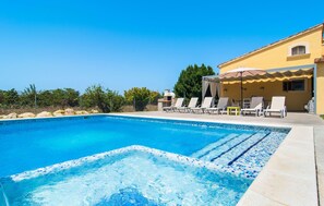 A clear blue swimming pool with lounge chairs and a covered seating area. - Beautiful home in Alcudia with private swimming pool, can be inside or outside (Alcudia)