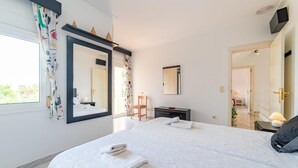 A modern bedroom with a large bed, a dresser, a chair, and a mirror. - Amazing home in Sa Coma with private swimming pool, can be inside or outside (Sa Coma)