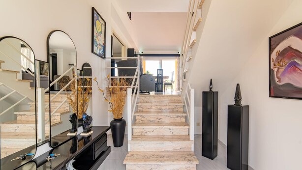 A modern interior with a staircase leading to a dining area, a black console table with keys, and a large mirror. - Amazing home in Sa Coma with private swimming pool, can be inside or outside (Sa Coma)