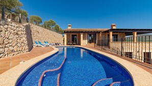 A swimming pool with a stone wall and a stone building with a tiled roof. - Nice home in Son Macia with private swimming pool, can be inside or outside (Son Macia)