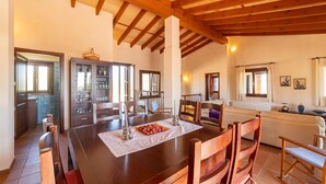 A dining area with a wooden table, chairs, and a cabinet with glass doors. - Nice home in Son Macia with private swimming pool, can be inside or outside (Son Macia)