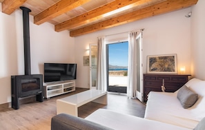 A living room with a TV, a fireplace, a sofa, and a view of the outdoors. - Lovely home in Alcudia with private swimming pool, can be inside or outside (Alcudia)