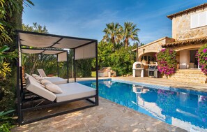 A poolside area with a covered seating area and a stone building with a grill and outdoor kitchen. - Cozy home in Palma with private swimming pool, can be inside or outside (Palma)