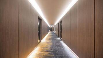 A long, narrow hallway with wooden walls and a carpeted floor.