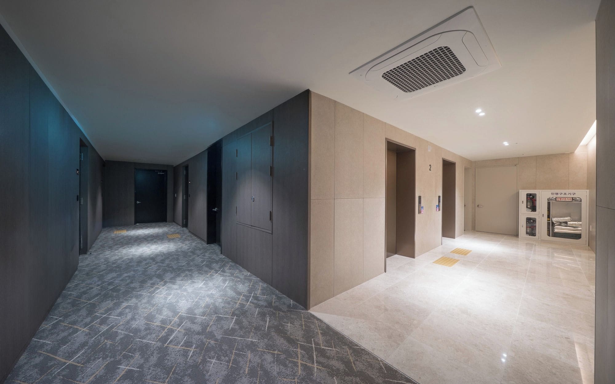 A hallway with a marble floor, a ventilation system, and a vending machine.