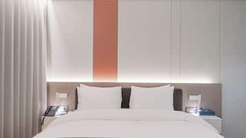 A hotel room with a bed, bedside tables, a phone, and a nightstand.