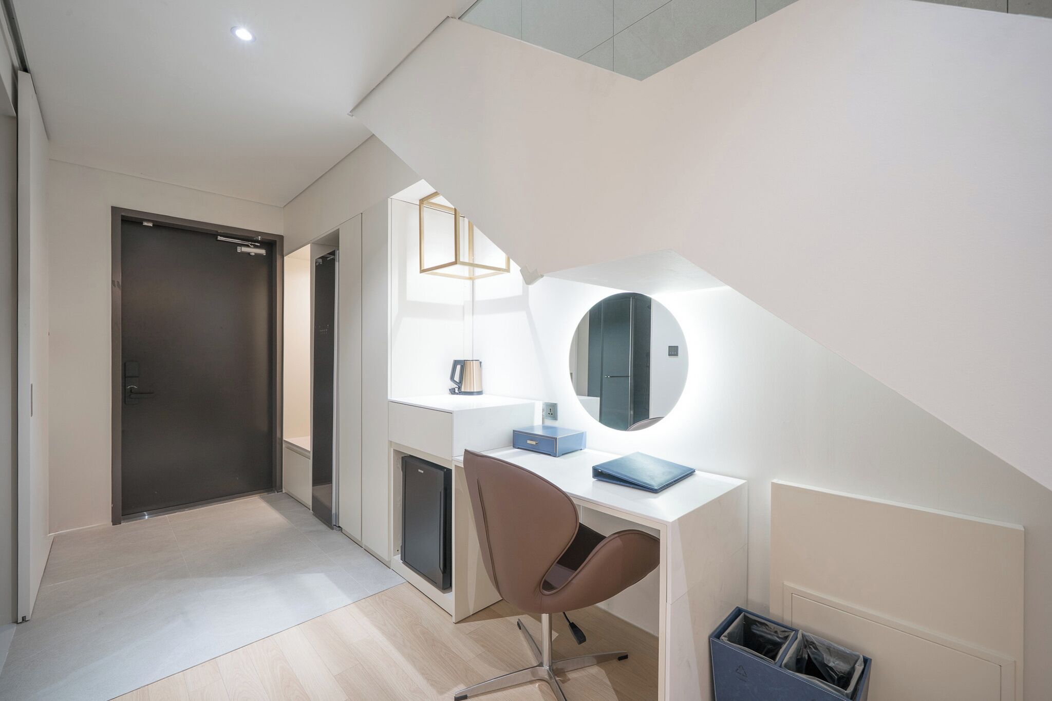 A modern office space with a desk, chair, and a large mirror.