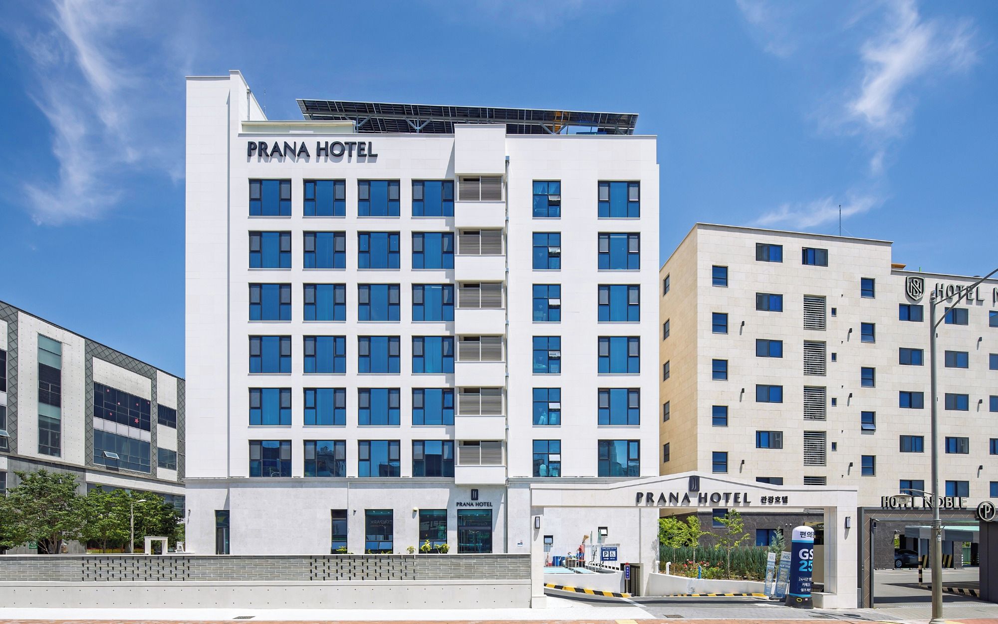 A modern hotel building with multiple floors and a prominent sign reading 'PRANA HOTEL'.
