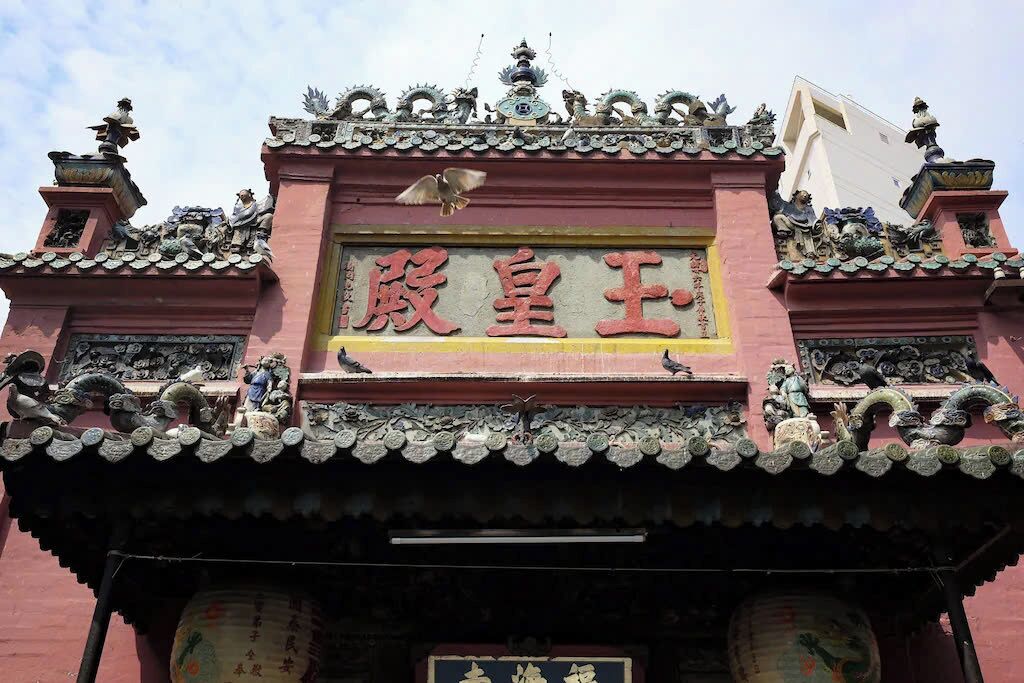 Un bâtiment traditionnel, orné de décorations raffinées, et sur lequel on peut voir une enseigne avec des caractères chinois.