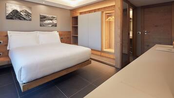 Quarto moderno com cama, armário de madeira e closet embutido com cabideiro.