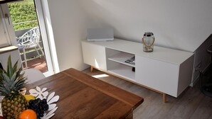 Ein modernes Zimmer mit einem Holztisch, einem weißen Schrank und einem Laptop darauf.