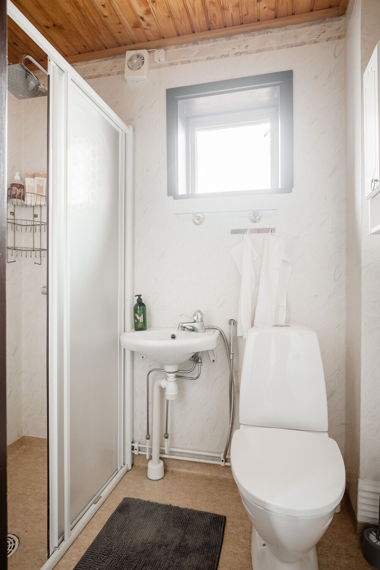 Ein Badezimmer mit Toilette, Waschbecken und Dusche.