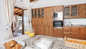 Una cocina con armarios de madera, horno de acero inoxidable y encimera de granito.