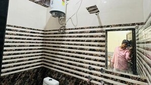 A bathroom with a toilet, sink, and mirror. - Gitanshi Palace (Ayodhya)