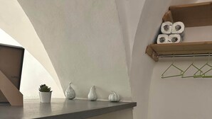 A corner of a room with a shelf holding a laptop, a small potted plant, and decorative items. - Independent apartment two minutes from the Duomo (Catania)