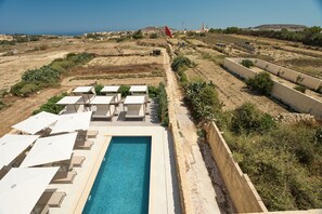 A pool area with lounge chairs and a clear view of the surrounding landscape. - Quaint Signature Hotel San Lawrenz (San Lawrenz)