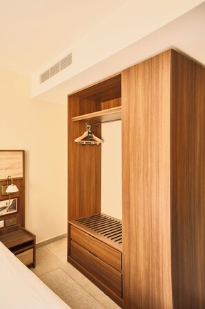 A wooden wardrobe with a hanging space and a bench. - Quaint Signature Hotel San Lawrenz (San Lawrenz)