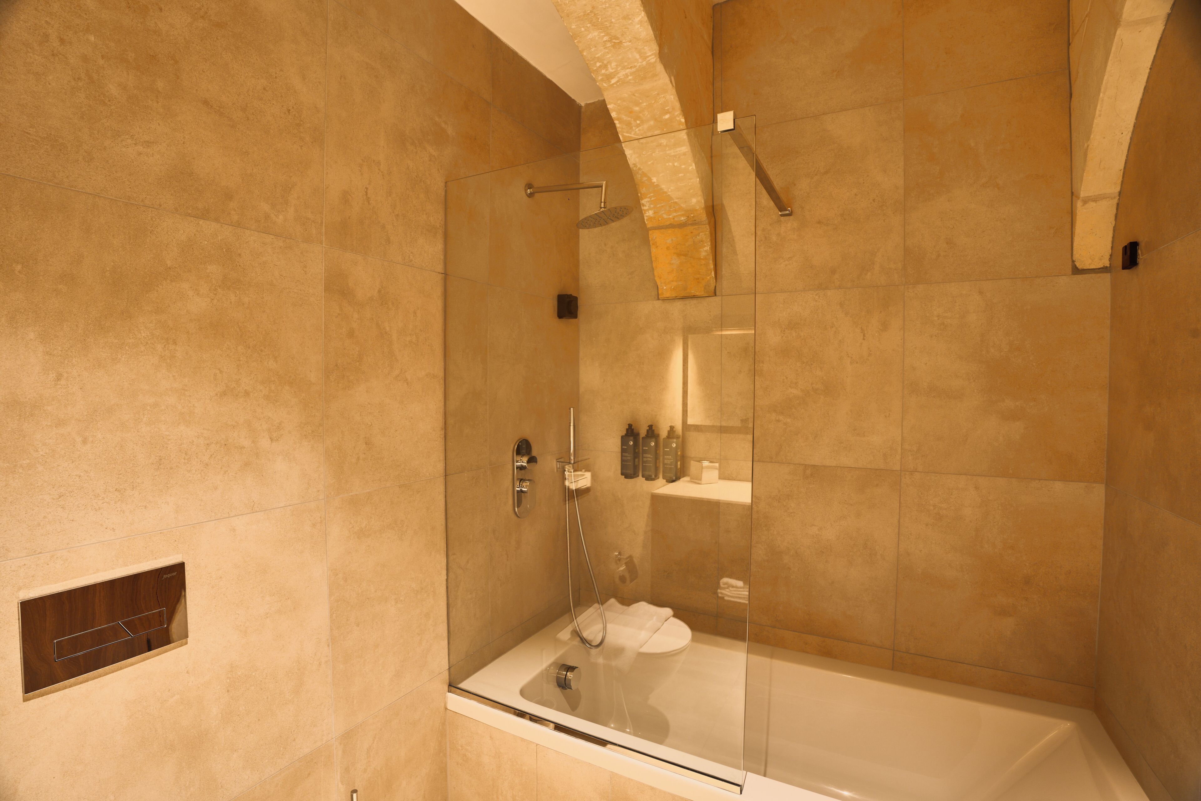 A modern bathroom with a glass-enclosed shower, a bathtub, and a toilet.