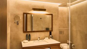Un baño moderno con un espejo grande, un lavabo y un inodoro.