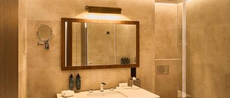 A modern bathroom with a large mirror, a sink, and a toilet.