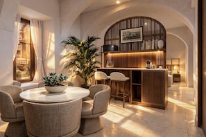 Ein modernes Interieur mit einem runden Esstisch, einer Bar und einer großen Pflanze in einem Topf.