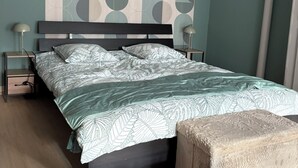 A bedroom with a bed, bedside tables, and a patterned wall. - Cosy, quiet house (Saint-Florentin)