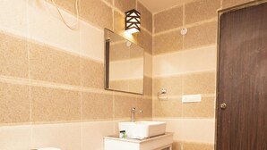 Un bagno con il water, un lavandino, uno specchio e una porta in legno.
