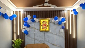 Ein modernes Wohnzimmer mit Marmorwand, Deckenventilator und einer Sofagarnitur.