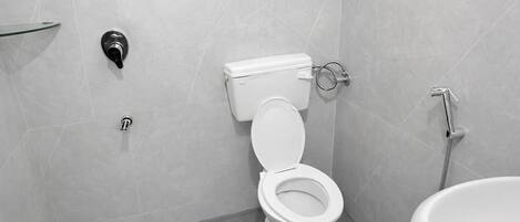 A modern bathroom with a toilet, bidet, and sink.