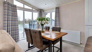 Un coin repas avec une table en bois, quatre chaises et un vase de fleurs.