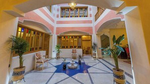 A lobby with a star-patterned floor, seating area, and a staircase leading to upper levels. - Riad Brothers (Marrakech)