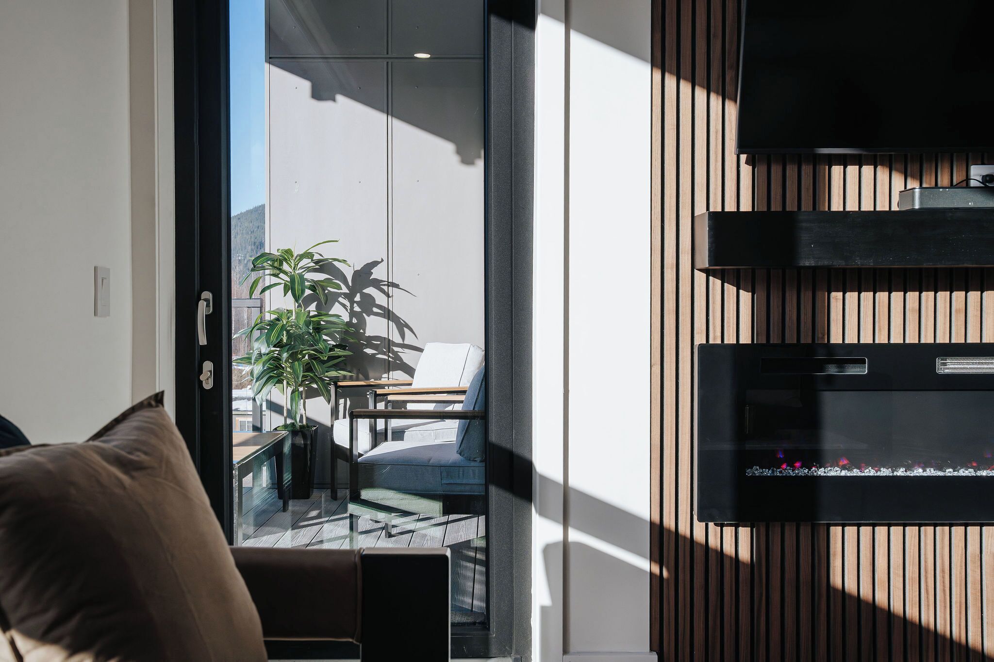 A modern living room with a glass door leading to a balcony.