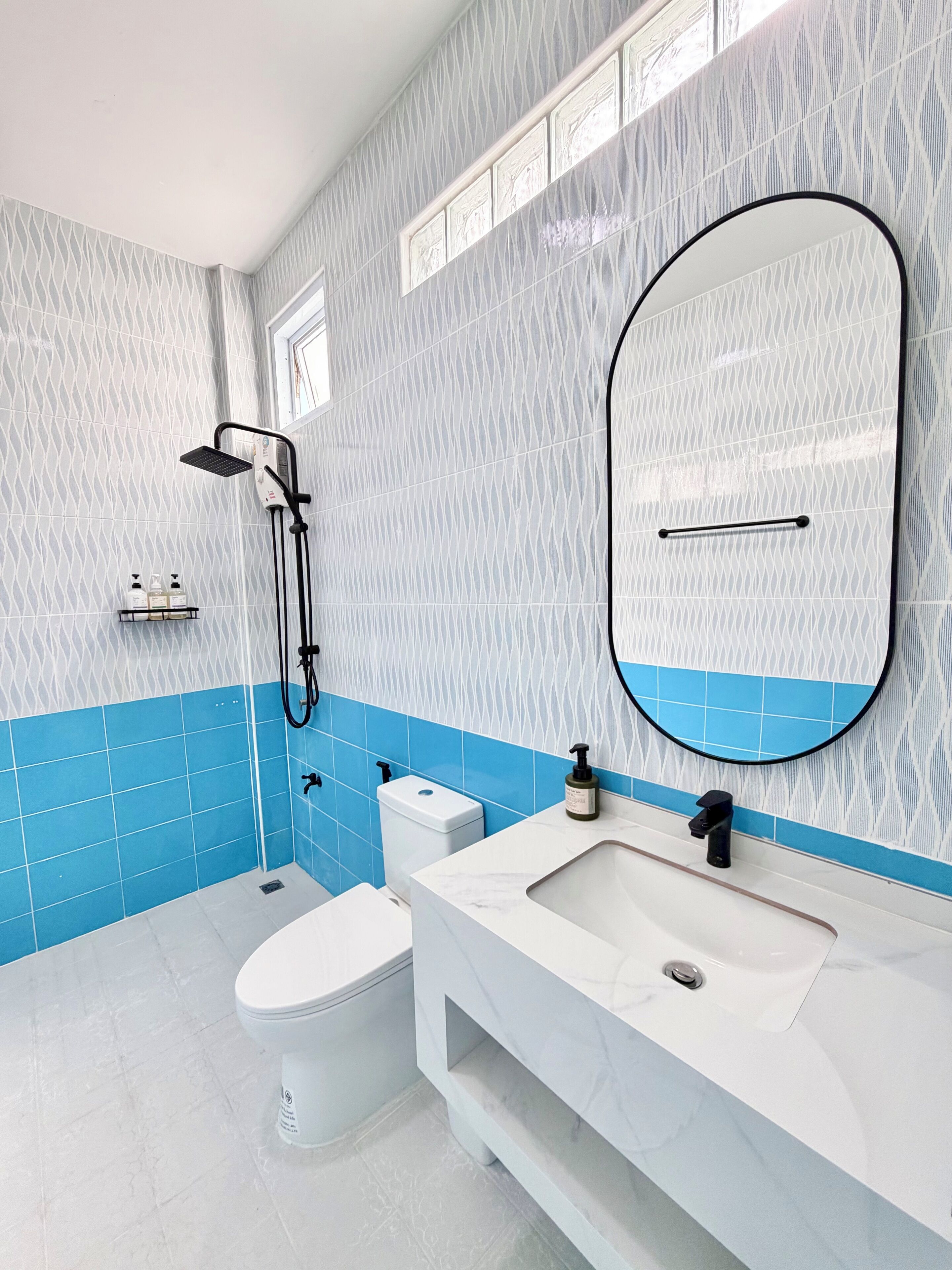 Une salle de bain moderne équipée d’une douche, de toilettes et d’un lavabo.