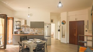 Une cuisine moderne avec un coin repas, un plancher en bois et une vue sur le salon.