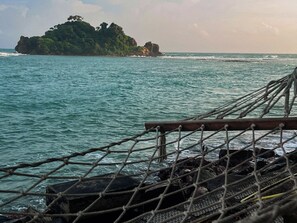 A rope barrier with a view of the ocean and a distant island.