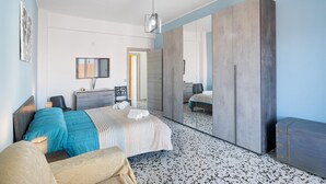 Une chambre à coucher moderne, avec un lit, des tables de chevet, un miroir et une armoire.