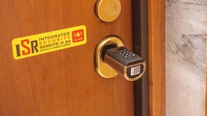 Une porte dotée d’une serrure de sécurité et d’un autocollant indiquant la présence de fonctions de sécurité intégrées.